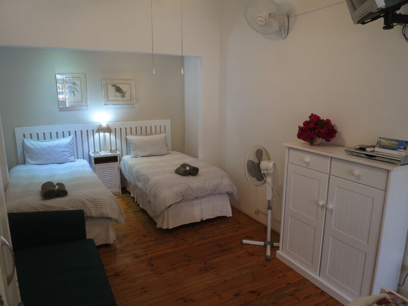 twin room no.4, view from kitchenette into bedroom area. note: no windows in bedroom area ( tv has been replaced!)